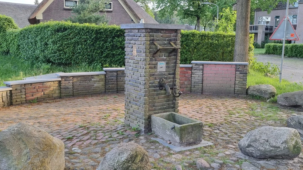 Die Dorfpumpe mit den niedrigen Mauern unterschiedlicher Höhe