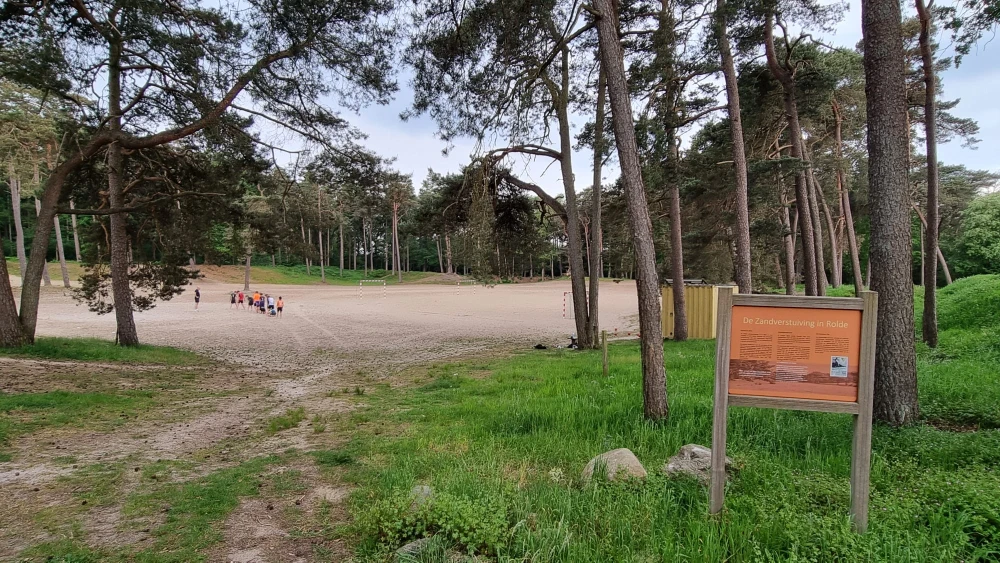 Die offene Sandfläche der Rolder Sandverwehung mit der Informationstafel
